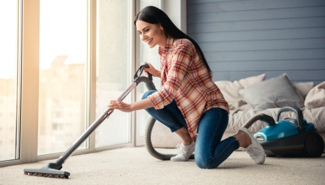 Lady cleaning carpet floor | Carpetland USA Granite & Flooring