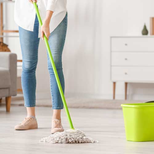 Lady cleaning floor | Carpetland USA Granite & Flooring